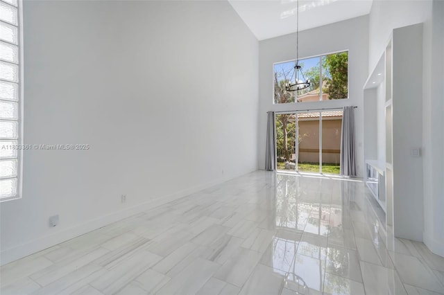 5050 Greenwich Preserve Ct, Boynton Beach, FL 33436 - unfurnished room featuring a towering ceiling and a chandelier