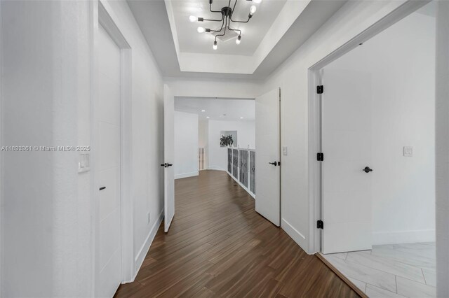 5050 Greenwich Preserve Ct, Boynton Beach, FL 33436 - hallway with a raised ceiling, wood finished floors, and a chandelier