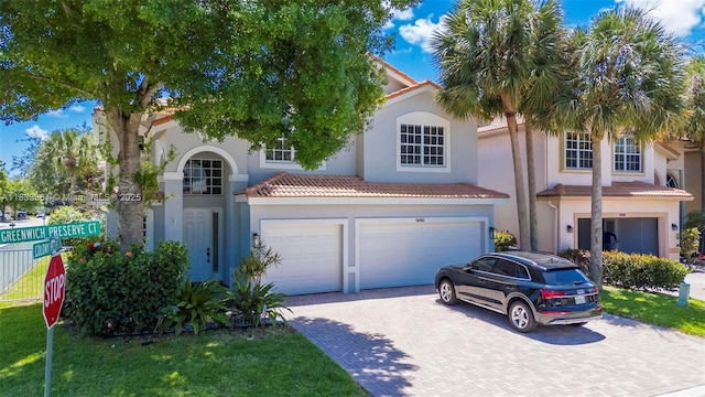 5050 Greenwich Preserve Ct, Boynton Beach, FL 33436 - mediterranean / spanish house featuring an attached garage, decorative driveway, stucco siding, and a tile roof