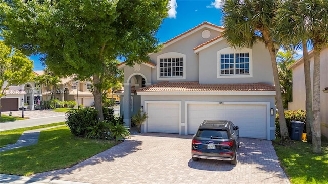 5050 Greenwich Preserve Ct, Boynton Beach, FL 33436 - mediterranean / spanish house with stucco siding, a garage, decorative driveway, a tiled roof, and a front lawn
