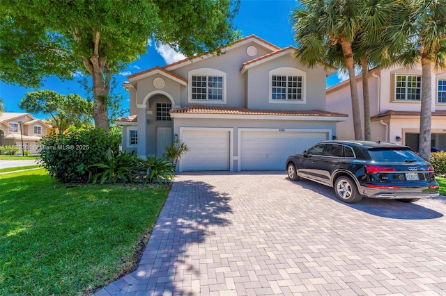 5050 Greenwich Preserve Ct, Boynton Beach, FL 33436 - mediterranean / spanish-style house featuring an attached garage, stucco siding, decorative driveway, a tile roof, and a front lawn
