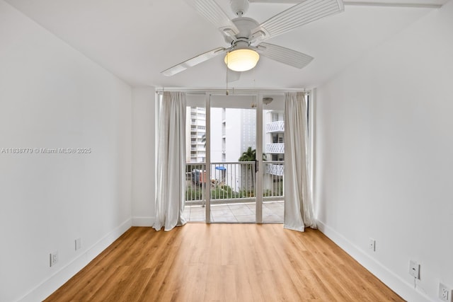 1440 Brickell Bay Dr Unit 307, Miami, FL 33131 - empty room with a ceiling fan, wood finished floors, and expansive windows