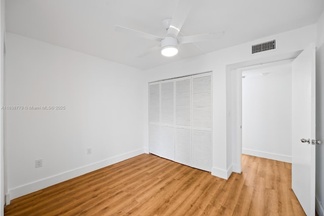 1440 Brickell Bay Dr Unit 307, Miami, FL 33131 - unfurnished bedroom featuring a closet, light wood-style flooring, and a ceiling fan
