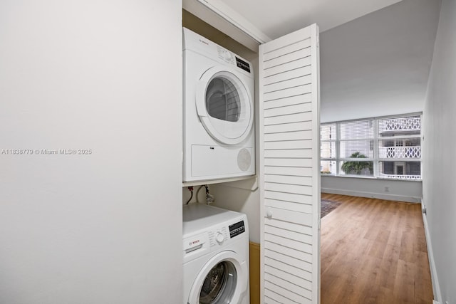 1440 Brickell Bay Dr Unit 307, Miami, FL 33131 - washroom featuring estacked washer and dryer and wood finished floors
