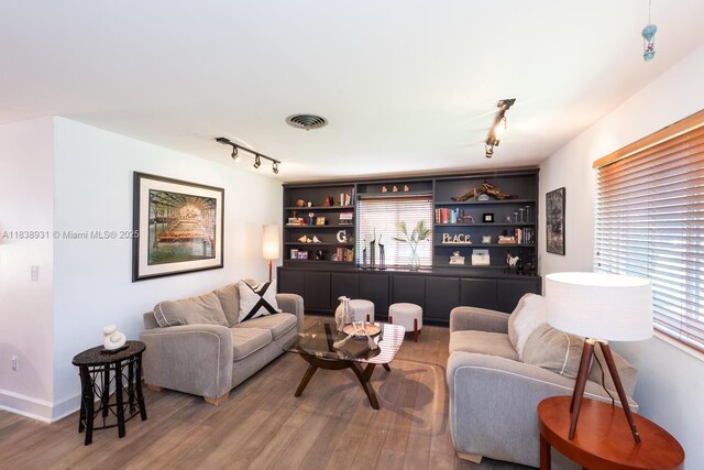 6957 SW 148th Ter, Palmetto Bay, FL 33158 - living room with rail lighting, wood finished floors, and built in shelves