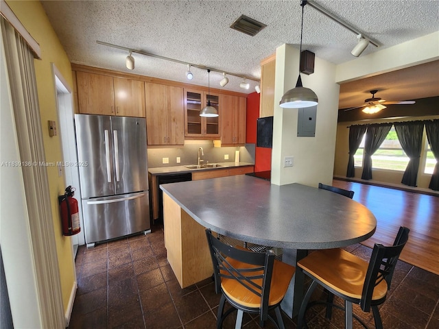 2451 SW 16th St, Fort Lauderdale, FL 33312 - kitchen with freestanding refrigerator, rail lighting, brown cabinetry, a textured ceiling, and dark countertops