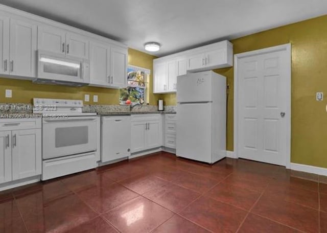 130 NE 21st Ct, Pompano Beach, FL 33060 - kitchen with white appliances, white cabinetry, and dark tile patterned flooring