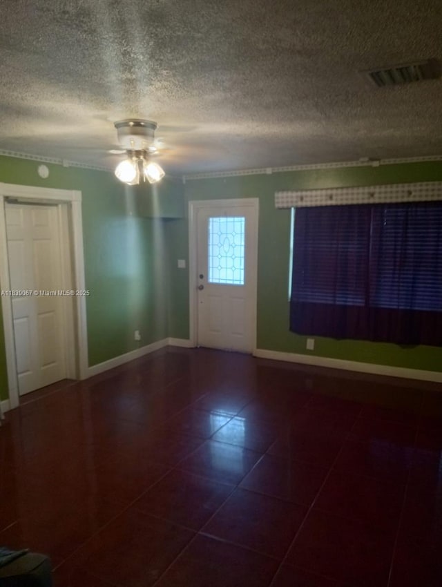 130 NE 21st Ct, Pompano Beach, FL 33060 - entryway with dark tile patterned flooring, a textured ceiling, crown molding, and a ceiling fan