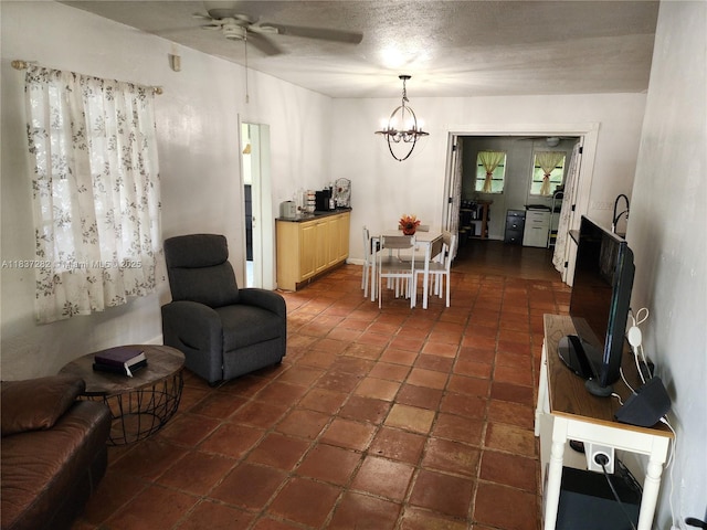 3521 E 8th Ave, Hialeah, FL 33013 - living area featuring ceiling fan, a chandelier, a textured ceiling, and dark tile patterned flooring