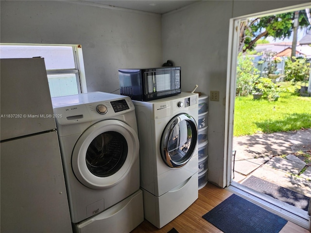 3521 E 8th Ave, Hialeah, FL 33013 - laundry area featuring washing machine and dryer and wood finished floors