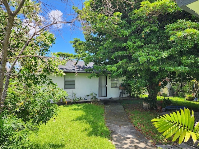 3521 E 8th Ave, Hialeah, FL 33013 - view of front of house featuring stucco siding, a shingled roof, and a front lawn