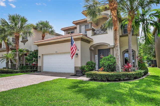 1086 Grove Park Cir, Boynton Beach, FL 33436 - mediterranean / spanish-style house featuring a garage, a front yard, decorative driveway, and stucco siding