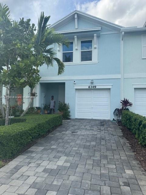 6349 Topsail Dr, West Palm Beach, FL 33413 - view of front of house featuring stucco siding, decorative driveway, and an attached garage