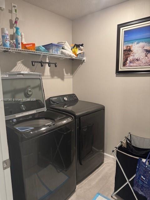 6349 Topsail Dr, West Palm Beach, FL 33413 - laundry area with washing machine and dryer and light colored carpet