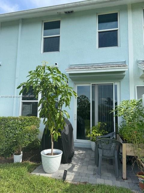 6349 Topsail Dr, West Palm Beach, FL 33413 - rear view of property featuring stucco siding and a patio
