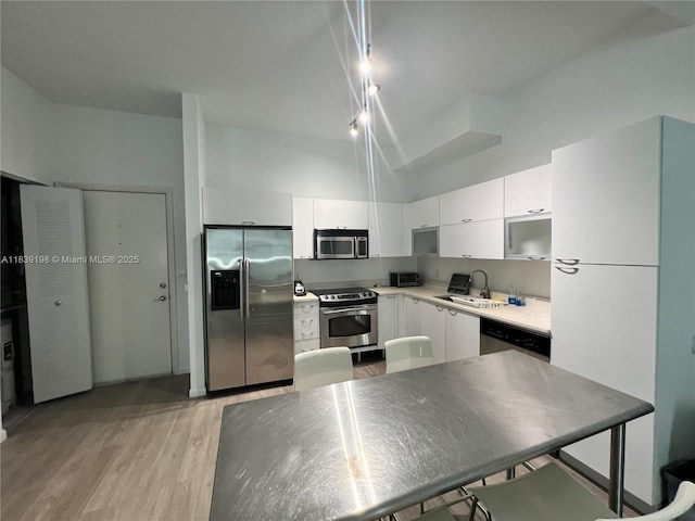 234 NE 3rd St Unit 905, Miami, FL 33132 - kitchen with stainless steel appliances, light wood-style floors, white cabinets, light countertops, and a high ceiling