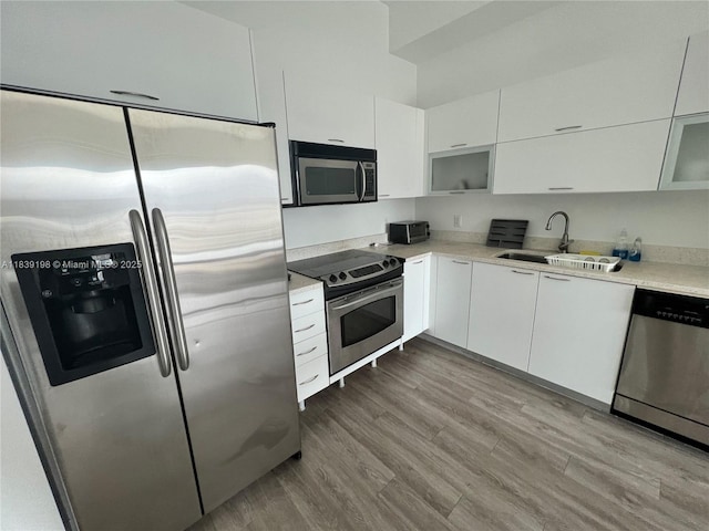 234 NE 3rd St Unit 905, Miami, FL 33132 - kitchen with stainless steel appliances, white cabinets, light countertops, modern cabinets, and glass insert cabinets