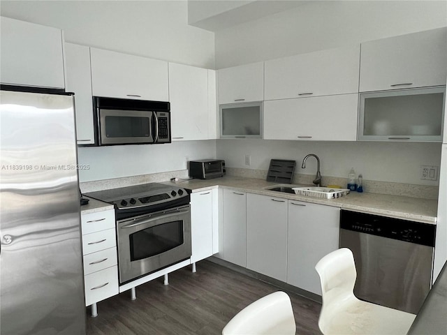 234 NE 3rd St Unit 905, Miami, FL 33132 - kitchen featuring stainless steel appliances, dark wood-type flooring, white cabinetry, light countertops, and modern cabinets