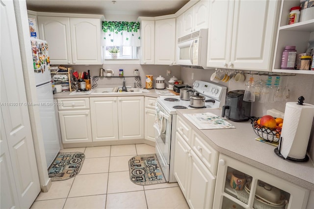 17425 NW 75th Pl Unit 101, Hialeah, FL 33015 - kitchen featuring white appliances, light tile patterned floors, light countertops, and white cabinets