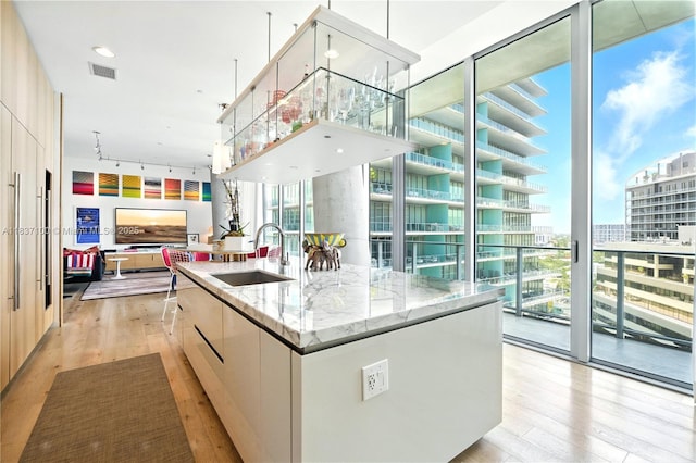 2675 S Bayshore Dr Unit 1601S, Miami, FL 33133 - kitchen with modern cabinets, light wood finished floors, a wall of windows, and open floor plan