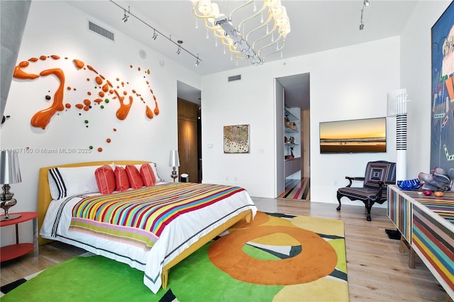 2675 S Bayshore Dr Unit 1601S, Miami, FL 33133 - bedroom featuring wood finished floors and a chandelier