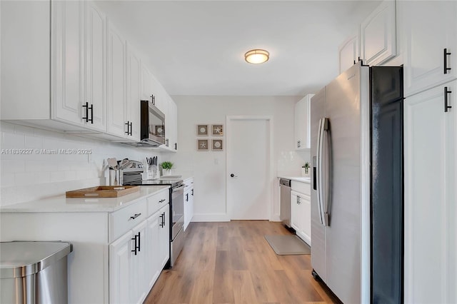 3141 SW 20th St, Fort Lauderdale, FL 33312 - kitchen featuring appliances with stainless steel finishes, decorative backsplash, light countertops, white cabinetry, and light wood-style flooring
