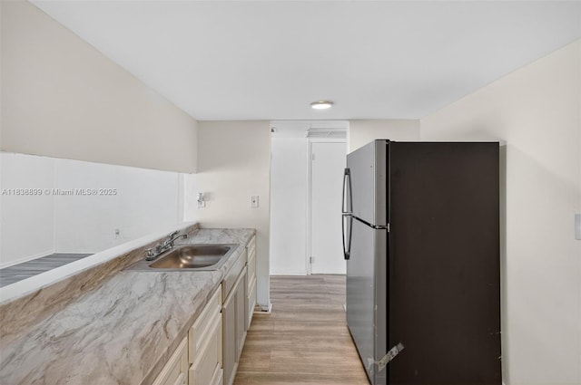 2767 NW 197th Ter, Miami Gardens, FL 33056 - kitchen featuring freestanding refrigerator, light wood-style flooring, and white cabinets
