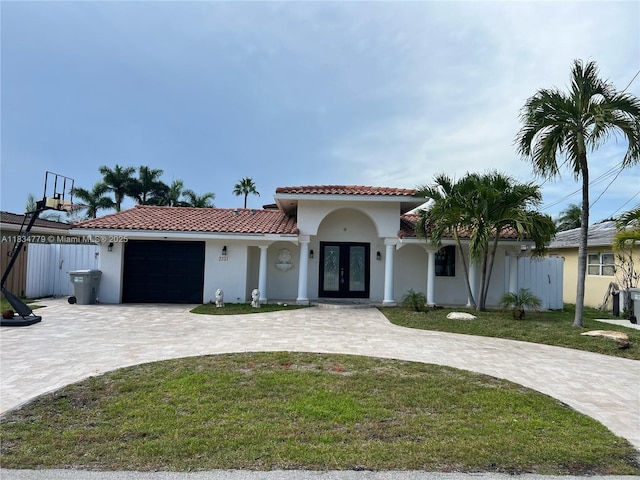 2321 SE 15th St, Pompano Beach, FL 33062 - mediterranean / spanish-style house with french doors, an attached garage, curved driveway, stucco siding, and a tile roof