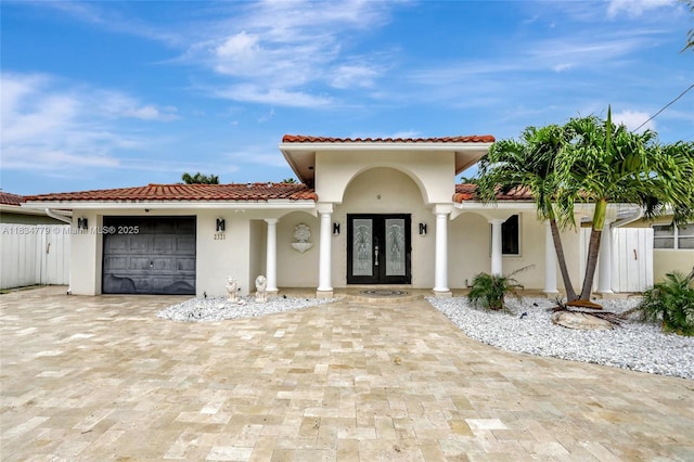 2321 SE 15th St, Pompano Beach, FL 33062 - mediterranean / spanish home featuring french doors, a garage, stucco siding, a tile roof, and decorative driveway