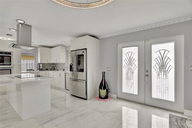 2321 SE 15th St, Pompano Beach, FL 33062 - kitchen with stainless steel appliances, french doors, white cabinetry, light countertops, and healthy amount of natural light