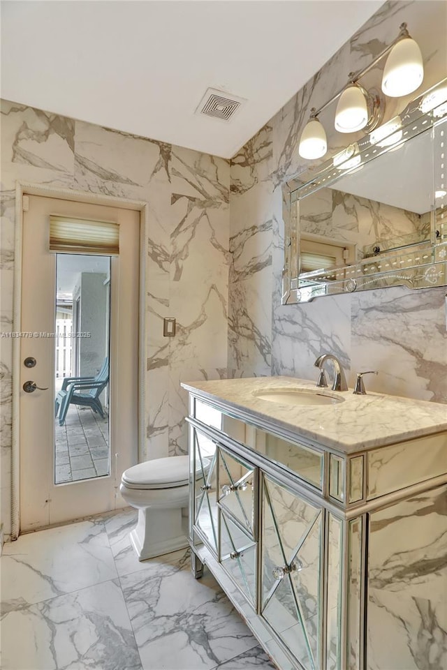 2321 SE 15th St, Pompano Beach, FL 33062 - bathroom with marble tiled flooring, vanity, and stone wall