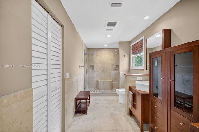 10871 SW 11th Mnr, Davie, FL 33324 - bathroom featuring a closet, tile walls, a shower stall, vanity, and a wainscoted wall