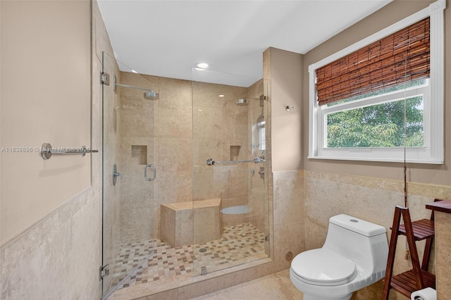10871 SW 11th Mnr, Davie, FL 33324 - bathroom featuring tile walls, a shower stall, wainscoting, and tile patterned floors