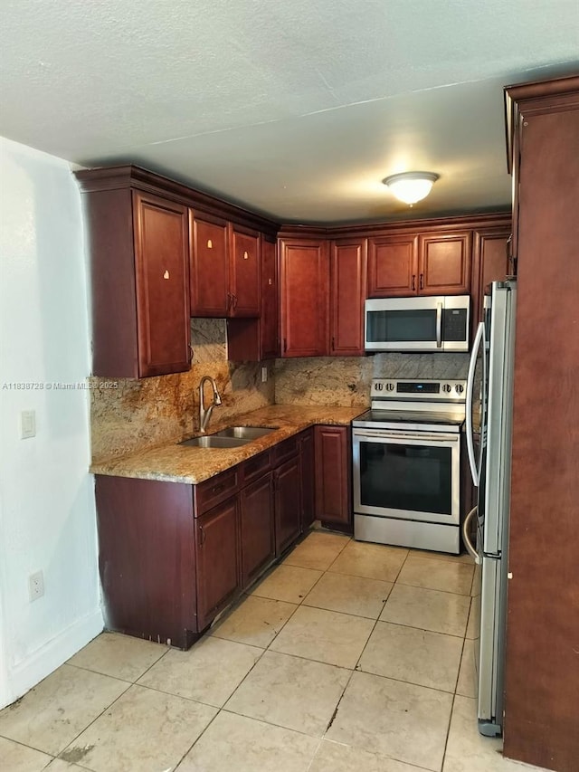 6023 SW 69th St Unit 78, South Miami, FL 33143 - kitchen featuring stainless steel appliances, decorative backsplash, light tile patterned flooring, and light stone countertops