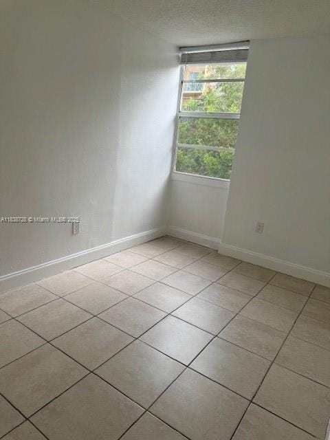 6023 SW 69th St Unit 78, South Miami, FL 33143 - spare room featuring baseboards and light tile patterned floors