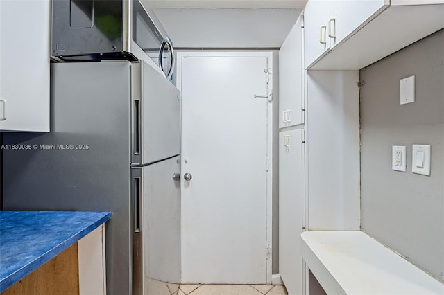 2899 Collins Ave Unit 931, Miami Beach, FL 33140 - kitchen featuring freestanding refrigerator, white cabinetry, and light tile patterned floors