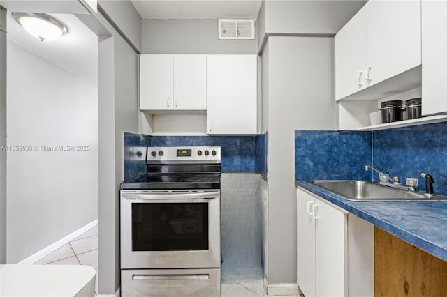 2899 Collins Ave Unit 931, Miami Beach, FL 33140 - kitchen with stainless steel range with electric cooktop, white cabinets, light tile patterned floors, open shelves, and dark countertops