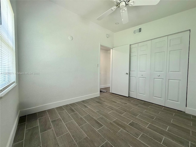3460 Normandy Dr, Port Charlotte, FL 33952 - unfurnished bedroom featuring multiple windows, wood finish floors, and a ceiling fan