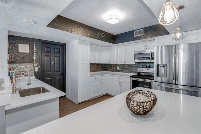 2239 NW 65th Ave, Margate, FL 33063 - kitchen featuring stainless steel appliances, light countertops, wood finished floors, and decorative backsplash