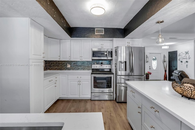 2239 NW 65th Ave, Margate, FL 33063 - kitchen with stainless steel appliances, light countertops, light wood-style flooring, and white cabinetry