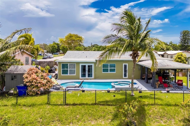 2239 NW 65th Ave, Margate, FL 33063 - back of property with french doors, a fenced backyard, a patio, a pool with connected hot tub, and a shed