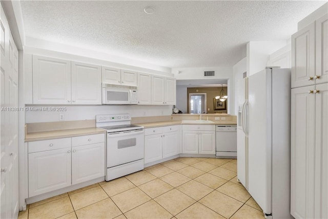 7751 Southampton Ter Unit 310, Tamarac, FL 33321 - kitchen featuring white appliances, a textured ceiling, light countertops, and white cabinetry