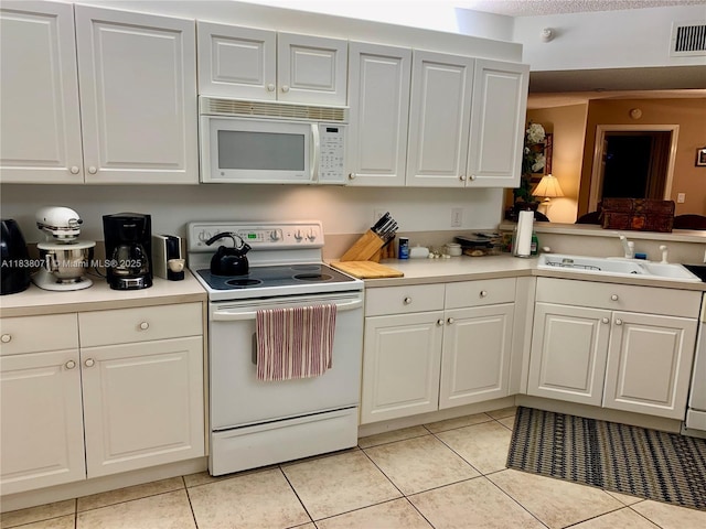 7751 Southampton Ter Unit 310, Tamarac, FL 33321 - kitchen featuring white appliances, light tile patterned floors, light countertops, white cabinetry, and a peninsula