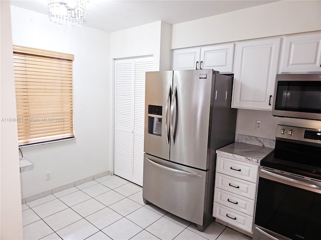 7270 Ashford Pl Unit 308, Delray Beach, FL 33446 - kitchen featuring appliances with stainless steel finishes, white cabinetry, light tile patterned floors, and a chandelier