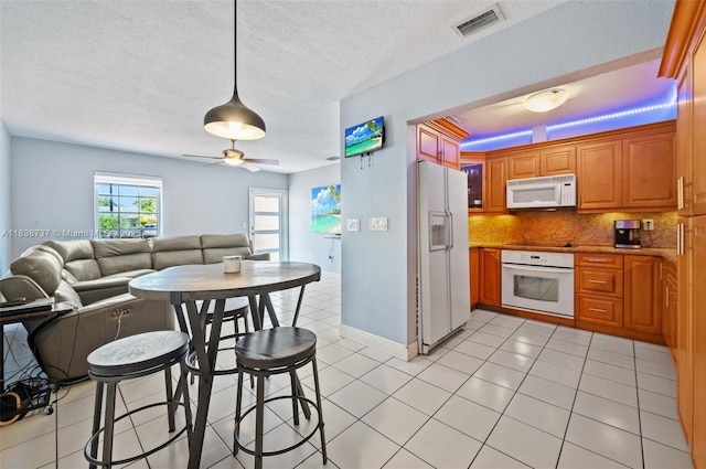 590 SW 62nd Ave, Miami, FL 33144 - kitchen with white appliances, open floor plan, tasteful backsplash, light tile patterned floors, and brown cabinetry