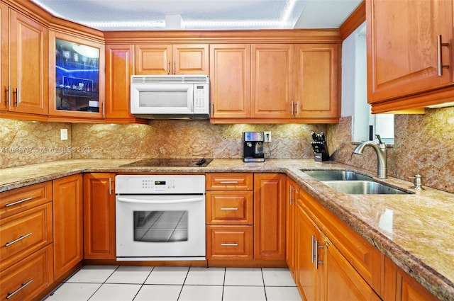 590 SW 62nd Ave, Miami, FL 33144 - kitchen with white appliances, brown cabinetry, glass insert cabinets, light tile patterned floors, and light stone counters