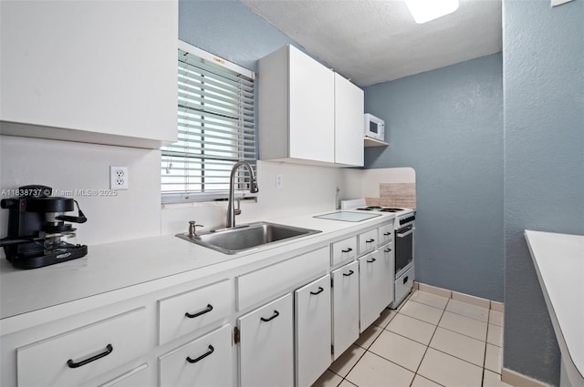 590 SW 62nd Ave, Miami, FL 33144 - kitchen with high end stainless steel range oven, white microwave, light countertops, white cabinets, and light tile patterned flooring