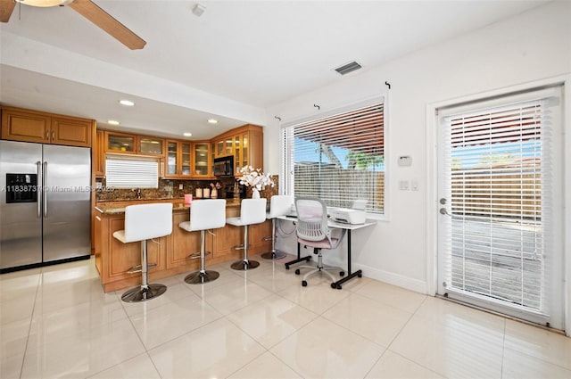 590 SW 62nd Ave, Miami, FL 33144 - kitchen with stainless steel refrigerator with ice dispenser, black microwave, brown cabinets, glass insert cabinets, and recessed lighting