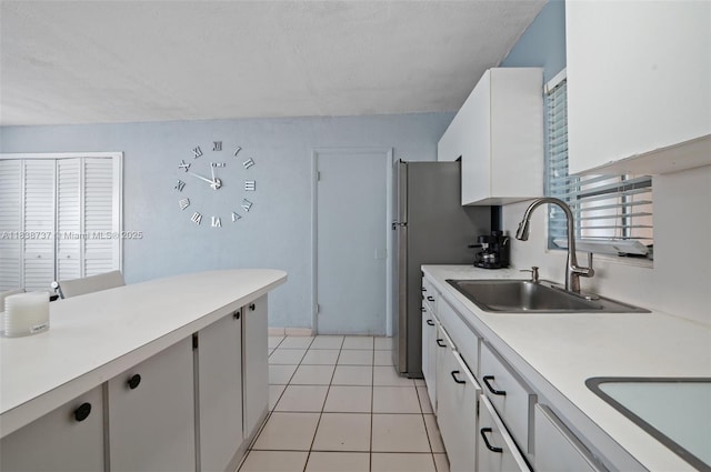 590 SW 62nd Ave, Miami, FL 33144 - kitchen with light countertops, white cabinets, light tile patterned flooring, and freestanding refrigerator