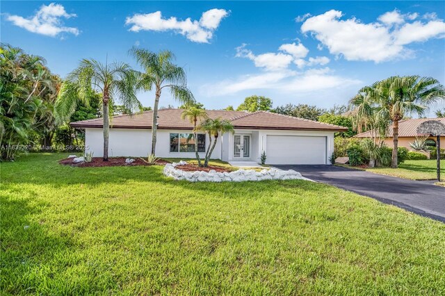 1655 NW 111th Way, Coral Springs, FL 33071 - single story home with asphalt driveway, an attached garage, a front lawn, and stucco siding